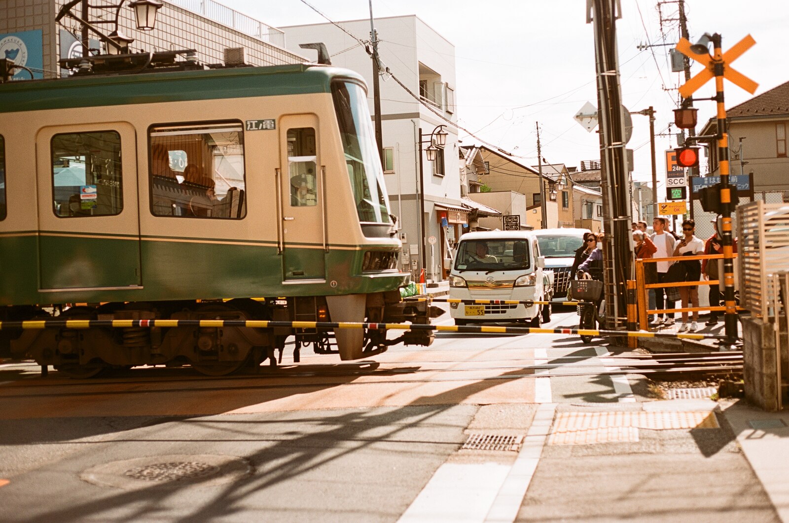 Tramway traversant un passage à niveau dans une rue japonaise